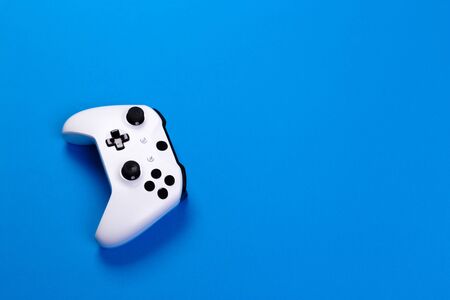Joystick gaming controller isolated on blue background , Video game console developed Interactive...