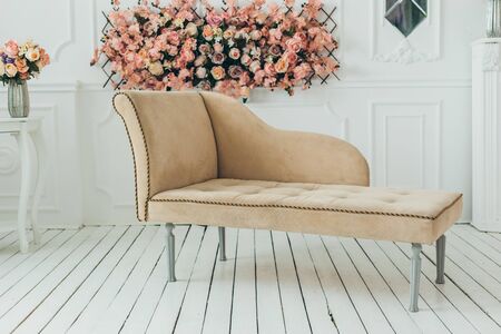Living room interior wall mock up with pink tufted armchair, pastel pillow, hanging lamp and flowers in vase on empty warm white background. の写真素材