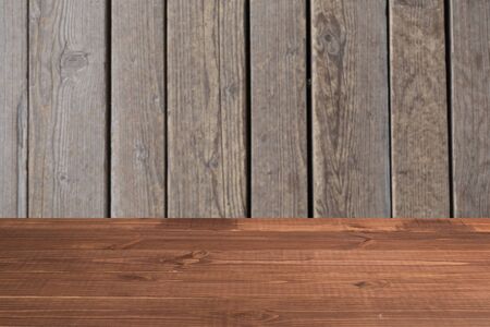 Wooden board empty table in front of a blurred background. Perspective brown wood over blurred wooden planks background - can be used to showcase or assemble your products. Mock upの写真素材