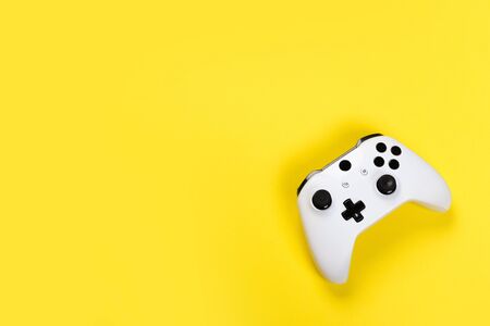 Joystick gaming controller isolated on yellow background , Video game console developed Interactive Entertainmentの写真素材