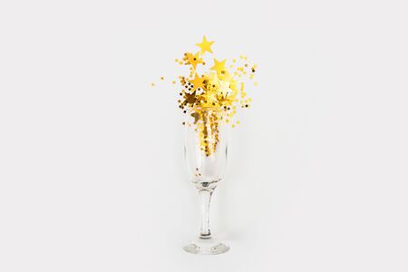 Glass of champagne with glitter on a white background, top view. Fun party. New Year or Christmasの写真素材