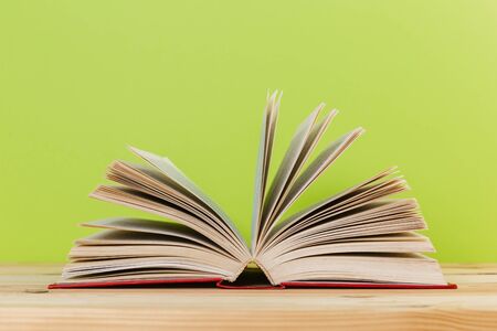 Simple Simple composition of many hardback books, unprocessed books on a wooden table and a green background. back to school. Copy space. Education.の写真素材