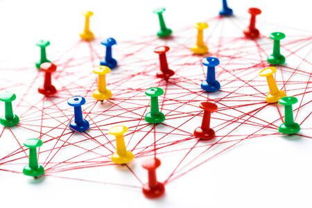 Network connection made from push pins and thread on blue background, close-up. の写真素材