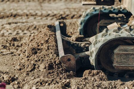 Excavator mechanical part for digging  for construction.
close up of tracked wheel on a construction site with yellow sandy soilの写真素材