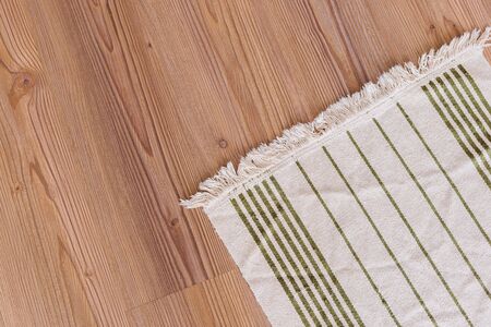 handmade light striped carpet on wooden floor