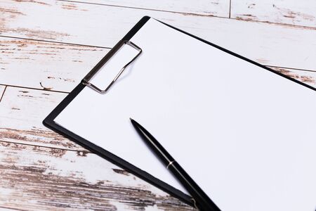 Blank paper with pen on wooden clipboard with space on background