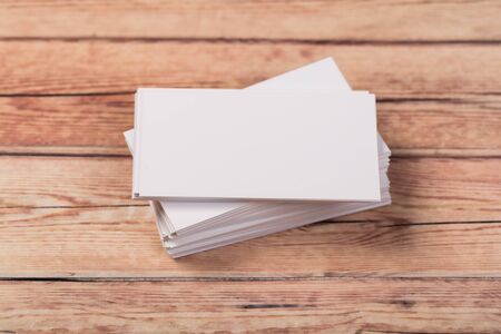 empty white business cards on a light natural wooden background 