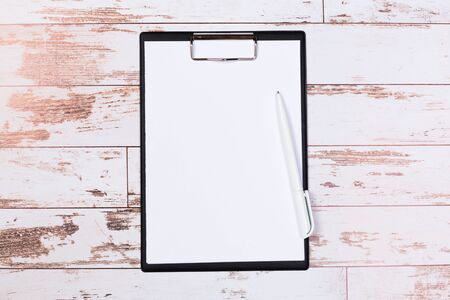 Blank paper with pen on wooden clipboard with space on background