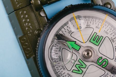 Modern nautical metal tourist compass on a blue background. travel or search conceptの写真素材