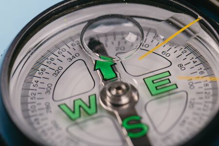 Modern nautical metal tourist compass on a blue background. travel or search conceptの写真素材
