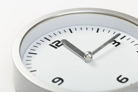 white with light metal minimalistic wall clock close-up on a light backgroundの写真素材