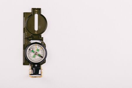 Modern navigation metal tourist compass on a light background. travel or search concept