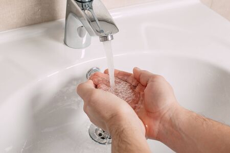 Washing hands under the water tap or faucet without soap. Hygiene concept detail. Beautiful hand and...