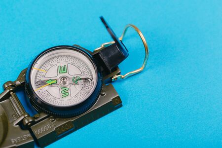 Modern nautical metal tourist compass on a blue background. travel or search conceptの写真素材