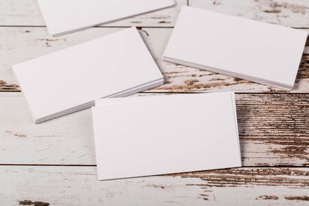 Mock up blank white business cards on light rustic natural wooden background.