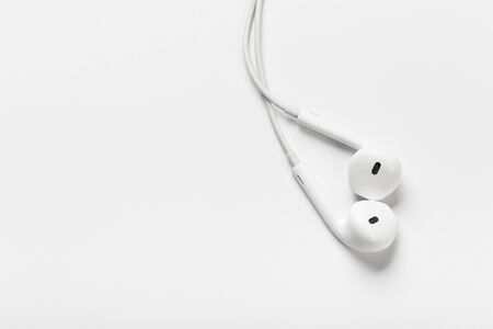 White modern headphones with a headset on a light gray background. concept of digital music