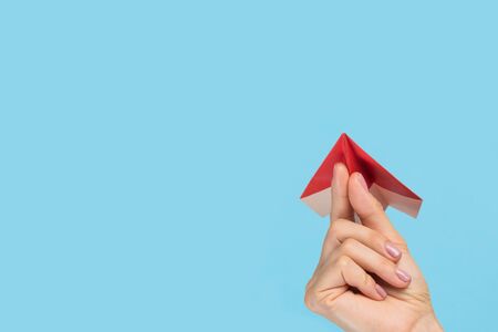 Hands holding the sign of paper airplane or message on blue studio background. Negative space, advertising. Social media, showing meaning, communicationの写真素材