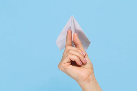 Hands holding the sign of paper airplane or message on blue studio background. Negative space, advertising. Social media, showing meaning, communicationの写真素材