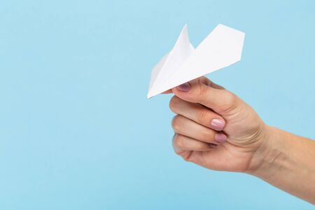 Hands holding the sign of paper airplane or message on blue studio background. Negative space, advertising. Social media, showing meaning, communicationの写真素材
