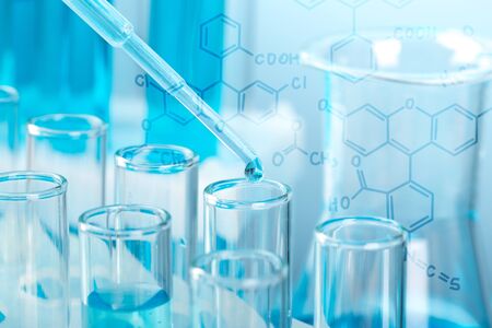 Laboratory glassware with a dropper dripping liquid into a test tube. scientific laboratory test...