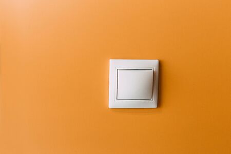 white light switch on a yellow wallの写真素材