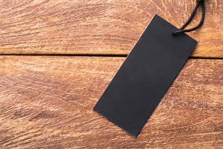 Clothing tag, label blank mockup template on a wooden backgroundの写真素材