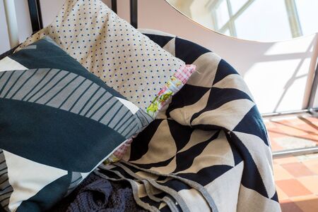 linen pillows with a geometric pattern lie on a plaid