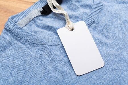 Clothing tag, label blank mockup on a clothes, to place your design.  fashion, people and shopping concept - close up price tag of clothing itemの写真素材