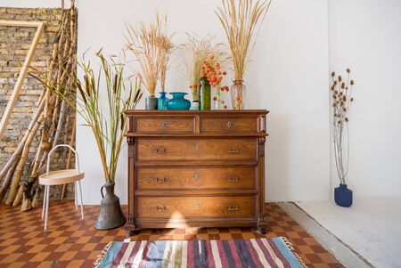 old antique old mahogany chest of drawers in a room with additional decorの写真素材