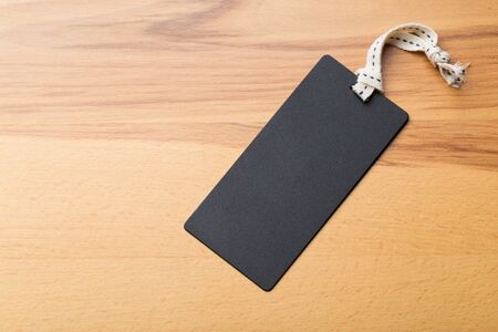 Clothing tag, label blank mockup template on a wooden backgroundの写真素材