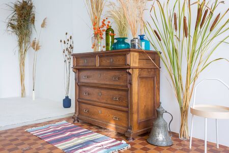 old antique old mahogany chest of drawers in a room with additional decorの写真素材