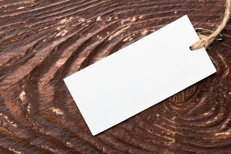 Clothing tag, label blank mockup template on a wooden background
