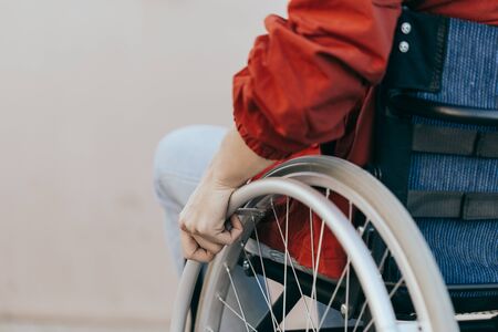 Unrecognizable disabled woman young woman in a wheelchair outdoors in a park. Recovery and...