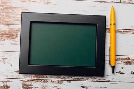 Clean vintage chalk board on a wooden table. Top view