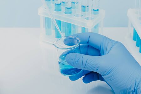 Laboratory glassware with test tubes. scientific laboratory equipment. hands of a scientific...