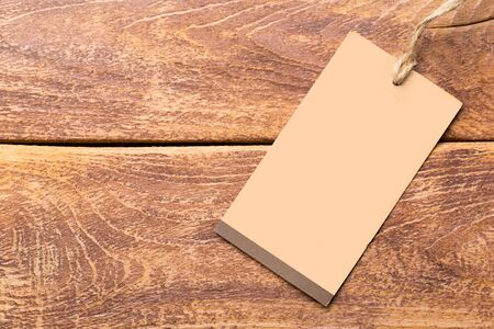 Clothing tag, label blank mockup template on a wooden background