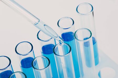Laboratory glassware with a dropper dripping liquid into a test tube. scientific laboratory test tubes, laboratory equipmentの写真素材
