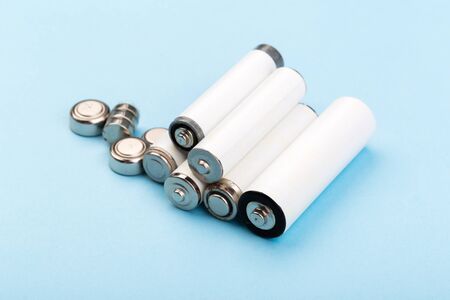 many new and used AA batteries on a blue background.の写真素材