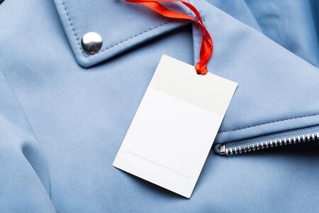 Clothing tag, label blank mockup on a clothes, to place your design.  fashion, people and shopping concept - close up price tag of clothing itemの写真素材