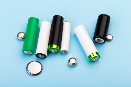 many new and used AA batteries on a blue background.の写真素材