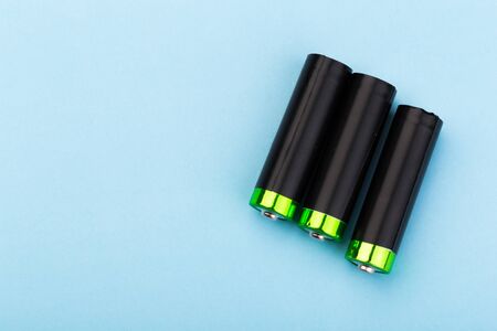 many new and used AA batteries on a blue background.