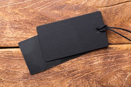 Clothing tag, label blank mockup template on a wooden background