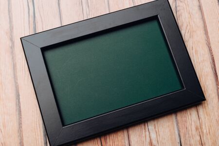 Clean vintage chalk board on a wooden table. Top viewの写真素材