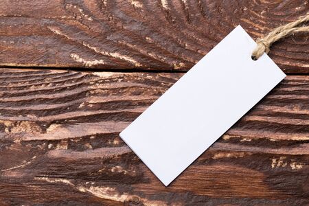 Clothing tag, label blank mockup template on a wooden backgroundの写真素材