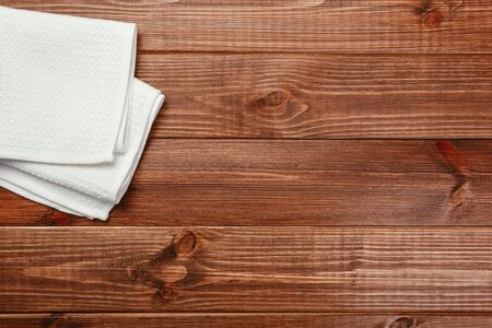 Top view on a dark wooden table with a linen kitchen towel or textile napkin. a tablecloth on a countertop made of old wood. Copy space for text.の写真素材