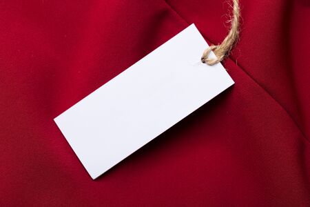Clothing tag, label blank mockup on a clothes, to place your design.  fashion, people and shopping concept - close up price tag of clothing itemの写真素材