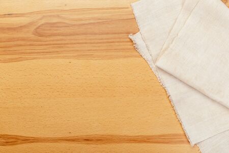 Top view on a wooden table with a linen kitchen towel or textile napkin. a tablecloth on a...