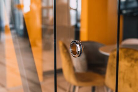 round metal doorknob in the glass door of a modern office
