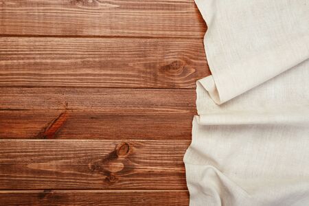 Top view on a dark wooden table with a linen kitchen towel or textile napkin. a tablecloth on a countertop made of old wood. Copy space for text.の写真素材