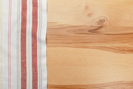 Top view on a wooden table with a linen kitchen towel or textile napkin. a tablecloth on a countertop made of old wood.の写真素材